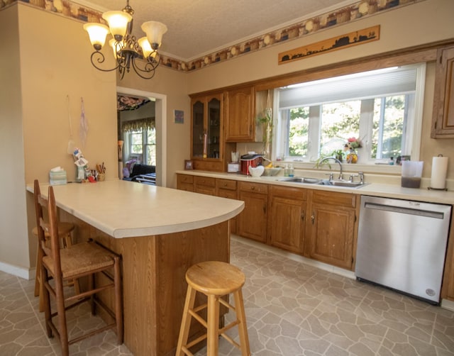 kitchen with stainless steel dishwasher, a breakfast bar, sink, and a chandelier