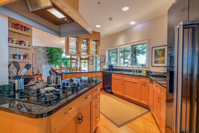 kitchen featuring black appliances, kitchen peninsula, sink, dark stone countertops, and light wood-type flooring