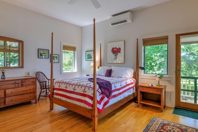 bedroom featuring multiple windows, an AC wall unit, and light hardwood / wood-style floors