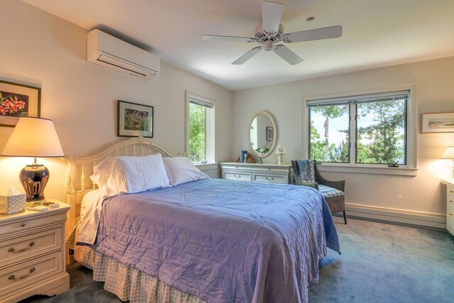 bedroom with dark carpet, ceiling fan, and a wall mounted air conditioner