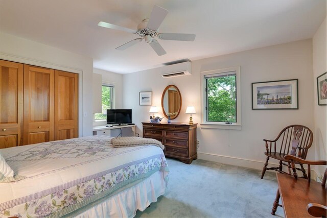 carpeted bedroom featuring a wall mounted AC, ceiling fan, and a closet