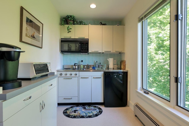 kitchen with a baseboard heating unit, black appliances, a healthy amount of sunlight, and backsplash