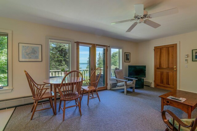 carpeted dining area featuring a baseboard heating unit and ceiling fan