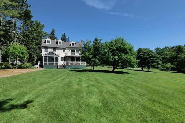 view of yard featuring a balcony and a sunroom