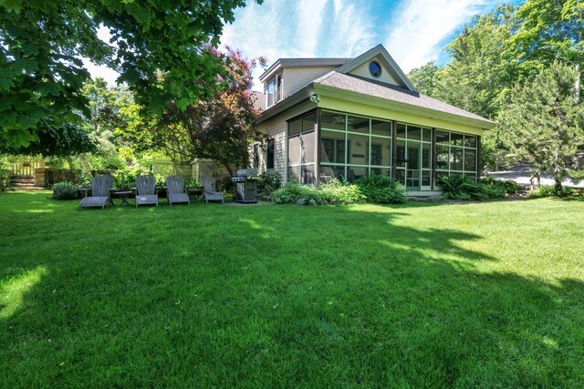 view of side of property with a sunroom and a yard