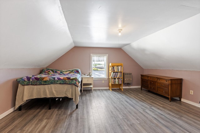 bedroom featuring vaulted ceiling, wood-type flooring, and heating unit