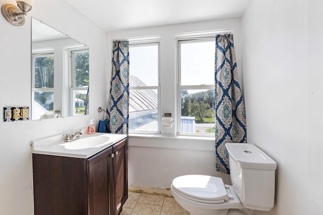 bathroom with vanity, toilet, and a wealth of natural light