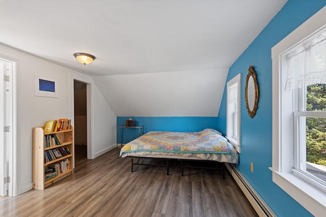 bedroom with lofted ceiling, hardwood / wood-style flooring, and baseboard heating