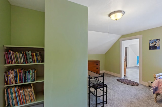 interior space featuring lofted ceiling, baseboard heating, and carpet floors