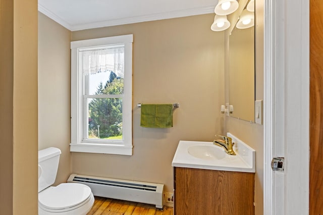 bathroom with hardwood / wood-style flooring, crown molding, toilet, a baseboard radiator, and vanity