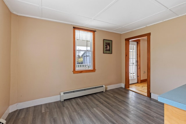 empty room featuring a baseboard radiator, dark hardwood / wood-style flooring, and a healthy amount of sunlight