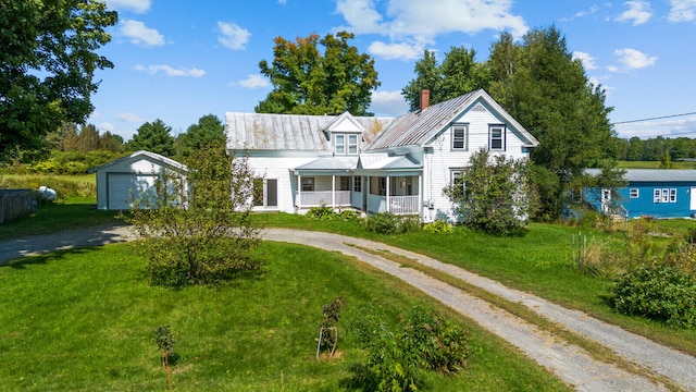 view of front of property with a front lawn, an outdoor structure, covered porch, and a garage