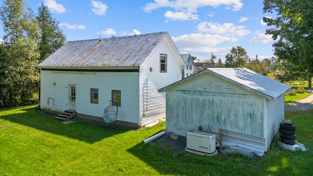 back of property with a yard and an outdoor structure