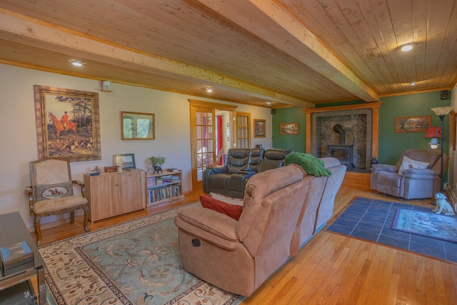 living room featuring a fireplace, beamed ceiling, light hardwood / wood-style flooring, and wooden ceiling