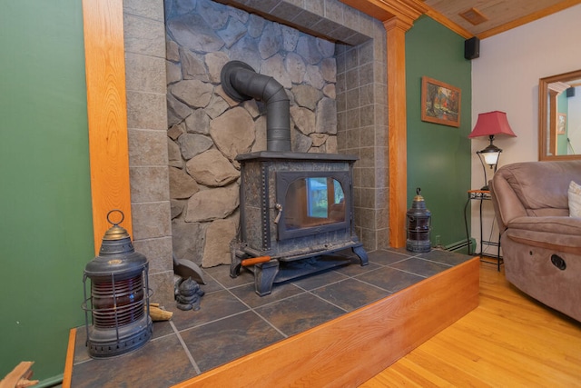 living room featuring crown molding, wood-type flooring, and a wood stove