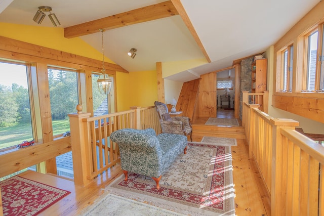 living area featuring light hardwood / wood-style floors and lofted ceiling with beams