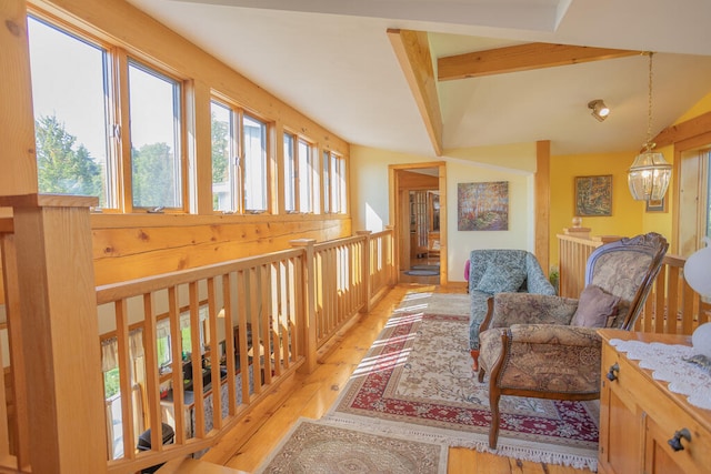 sitting room with beamed ceiling, an inviting chandelier, and light hardwood / wood-style floors