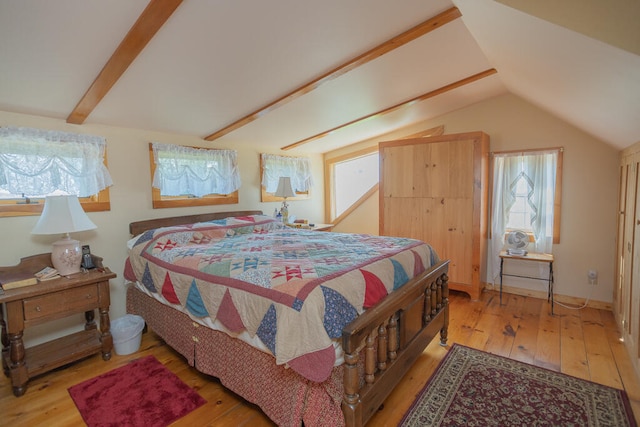 bedroom with light wood-type flooring and vaulted ceiling