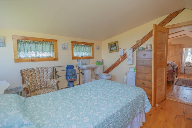 bedroom with vaulted ceiling and light hardwood / wood-style flooring