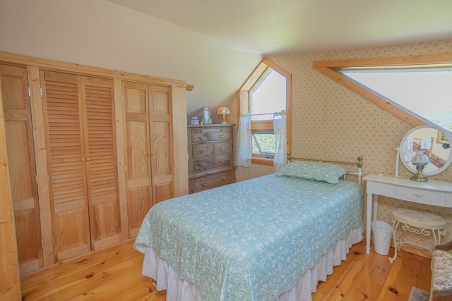 bedroom featuring lofted ceiling and light hardwood / wood-style floors