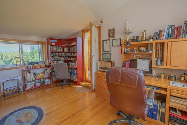 office with built in desk and light hardwood / wood-style floors