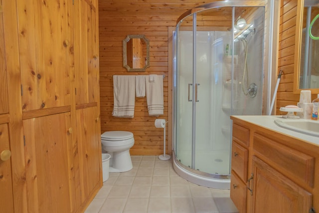 bathroom with tile patterned flooring, walk in shower, toilet, wood walls, and vanity