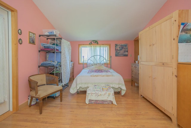 bedroom featuring light wood-type flooring and vaulted ceiling