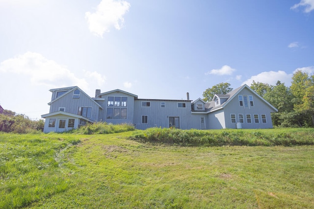 rear view of property with a lawn