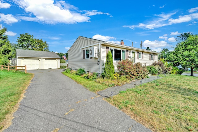 view of front facade featuring an outdoor structure, a garage, and a front lawn