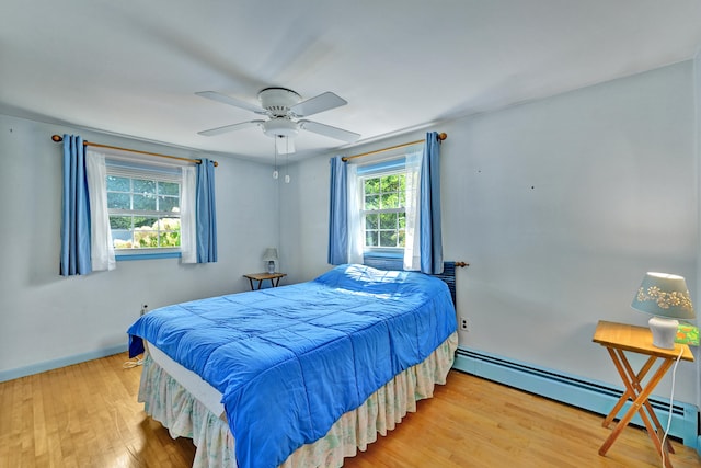 bedroom with wood-type flooring, ceiling fan, and a baseboard radiator