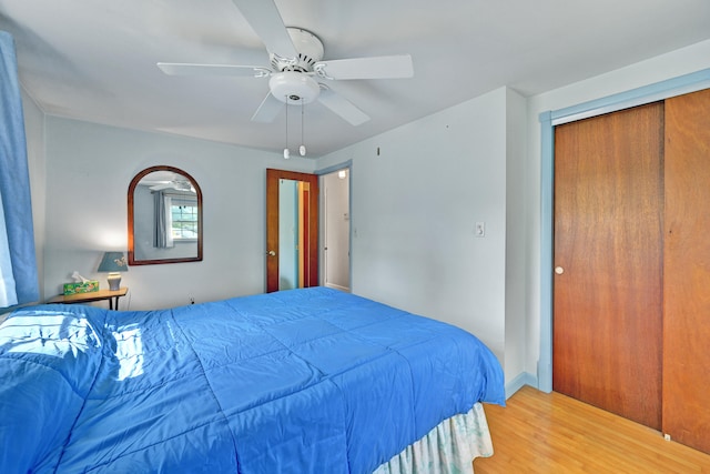 bedroom featuring wood-type flooring, ceiling fan, and a closet