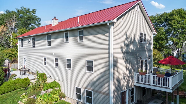 view of side of property with a wooden deck and a patio area