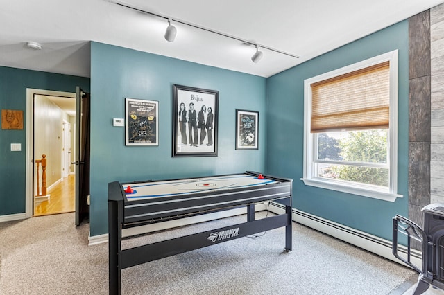 rec room with rail lighting, a baseboard radiator, and carpet floors