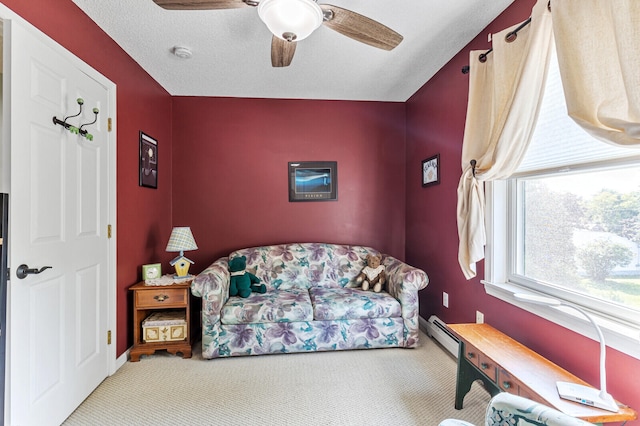 carpeted living room with a baseboard heating unit, ceiling fan, and a textured ceiling