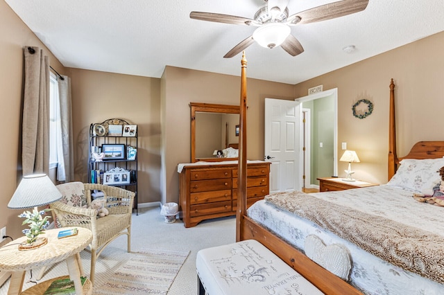 carpeted bedroom featuring ceiling fan and a textured ceiling