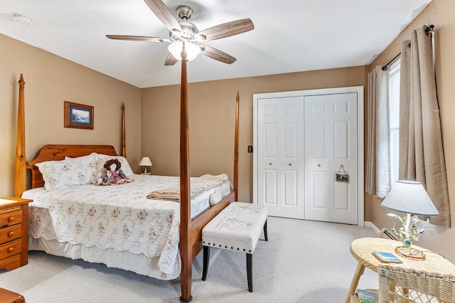 carpeted bedroom featuring a closet, ceiling fan, and a textured ceiling