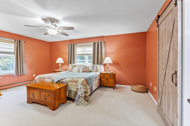 bedroom featuring a barn door, ceiling fan, baseboard heating, and carpet flooring