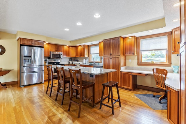 kitchen with plenty of natural light, stainless steel appliances, and light hardwood / wood-style flooring