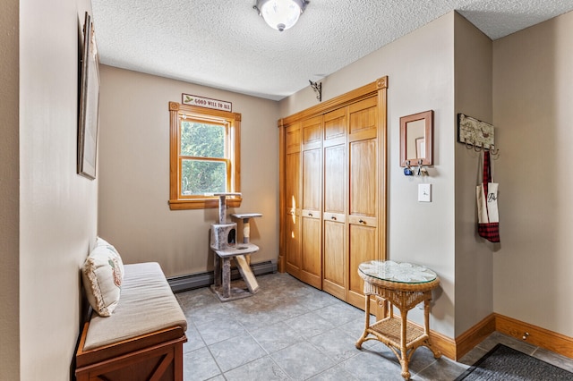 tiled entrance foyer with a textured ceiling and baseboard heating