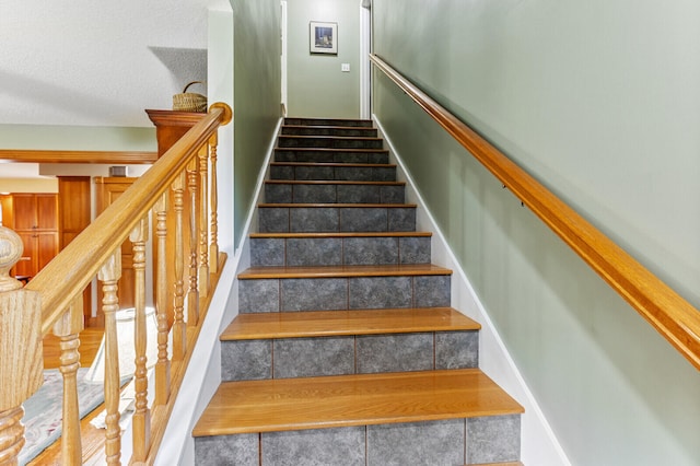 stairway with hardwood / wood-style flooring and a textured ceiling