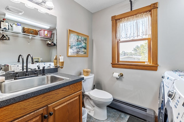 bathroom with vanity, a baseboard radiator, washer and dryer, tile patterned flooring, and toilet