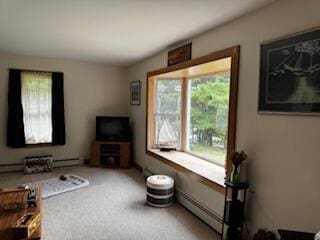 carpeted living room featuring a baseboard heating unit