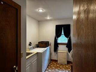 laundry area with independent washer and dryer and cabinets