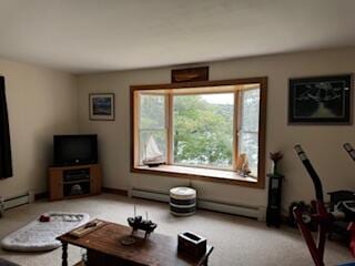 exercise room featuring light carpet and baseboard heating