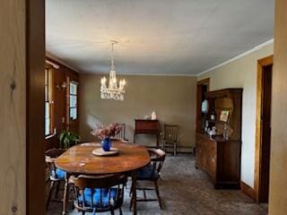 dining area featuring a notable chandelier, dark carpet, and crown molding