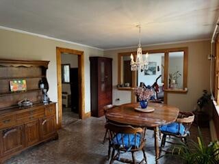 dining room with a notable chandelier and ornamental molding