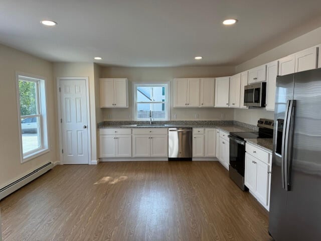 kitchen featuring appliances with stainless steel finishes, dark wood-type flooring, and white cabinets