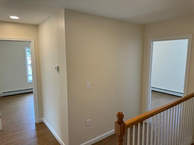 hallway with a baseboard radiator and hardwood / wood-style flooring