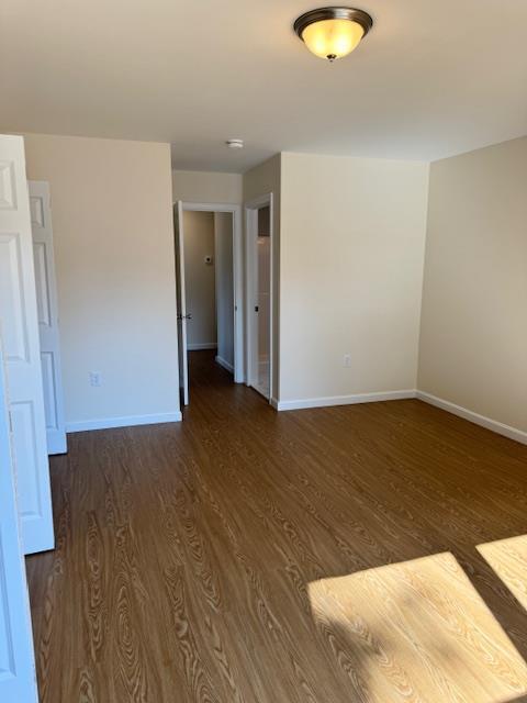 unfurnished room with dark wood-type flooring