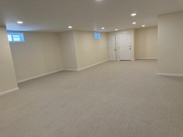 basement featuring light colored carpet